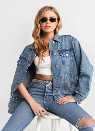Modelo usando um top com calça e jaqueta jeans e óculos escuros